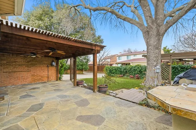 a view of a backyard with table and chairs under an umbrella