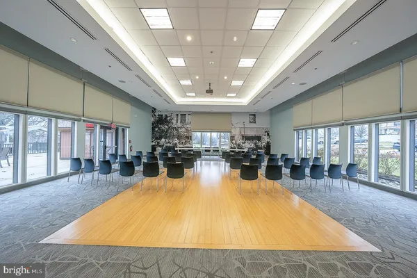 a large hall with dining table and couches with a large window