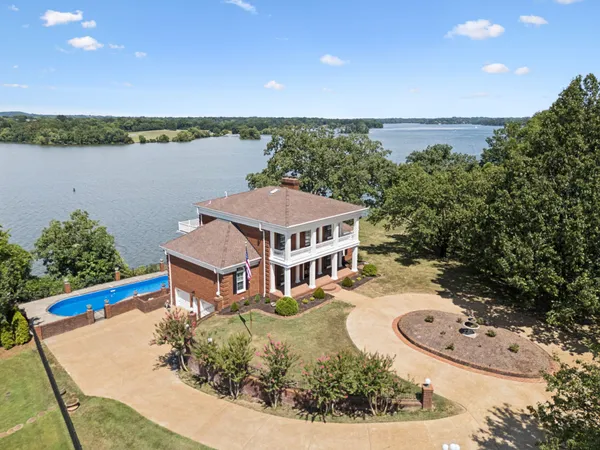 an aerial view of a house with outdoor space and lake view