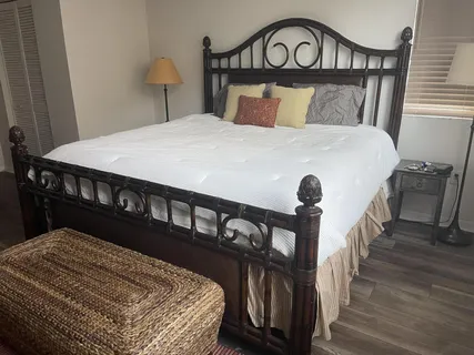 a bedroom with a bed a wooden floor and a table