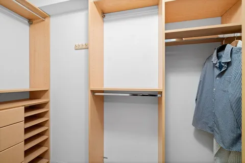 a view of walk in closet with empty racks