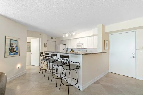 a view of a dining room with furniture and kitchen view