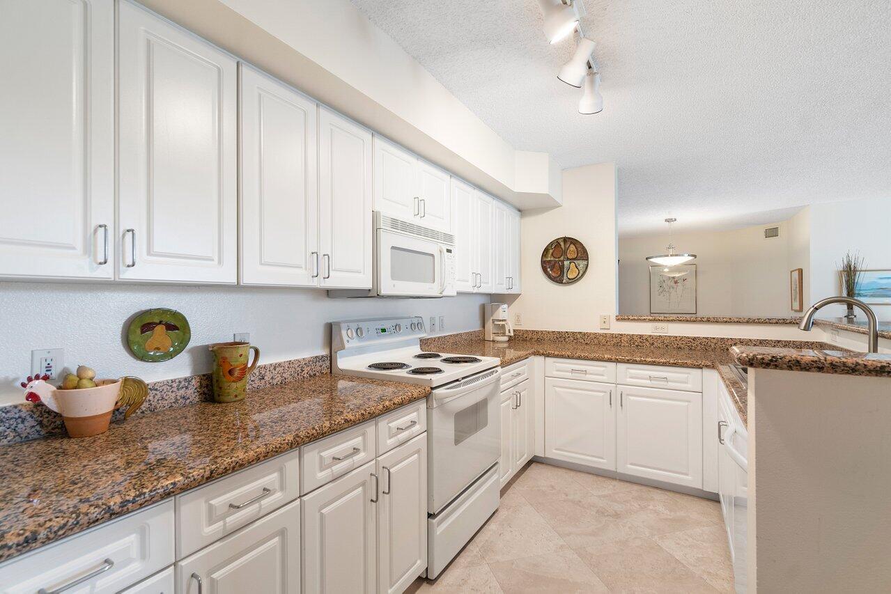 3594 South Ocean Boulevard, Unit 205 Highland Beach, FL 33487 - Photo 9 of 44 a kitchen with cabinets and window