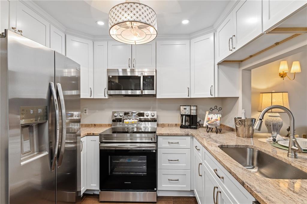 1800 Clairmont Lake Decatur, GA 30033 - Photo 12 of 31 a kitchen with stainless steel appliances granite countertop a sink a stove a refrigerator cabinets and a window