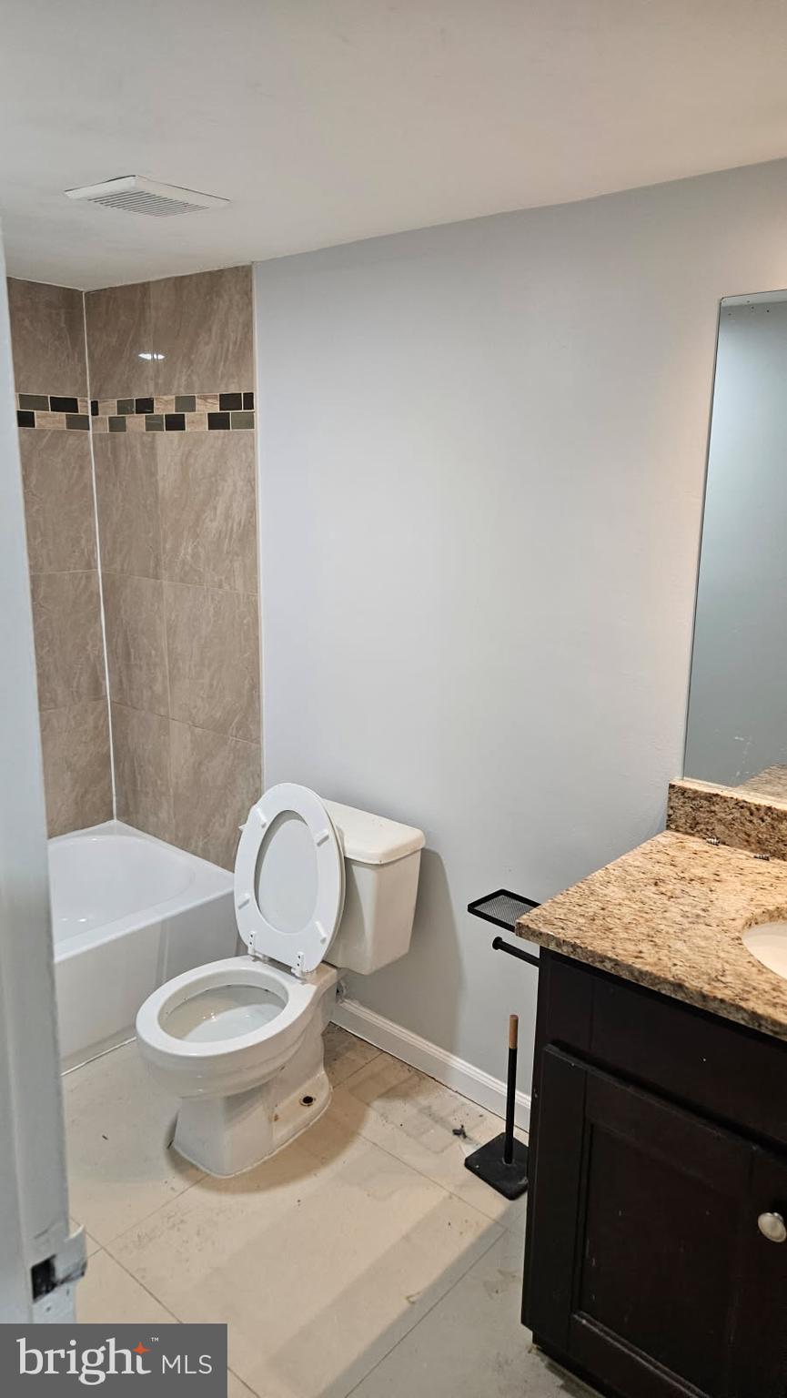 8671 Greenbelt Road, Unit 101 Greenbelt, MD 20770 - Photo 8 of 15 a bathroom with a granite countertop toilet sink and shower