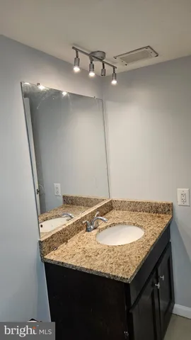 a bathroom with a granite countertop sink a vanity and a mirror