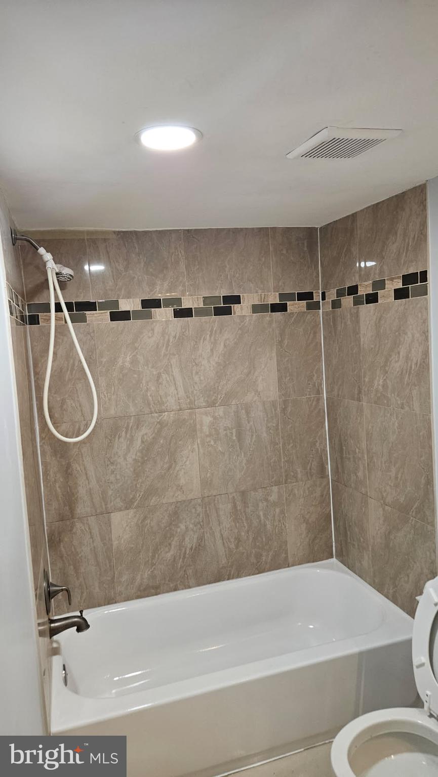 8671 Greenbelt Road, Unit 101 Greenbelt, MD 20770 - Photo 10 of 15 a bathroom with a shower and a toilet