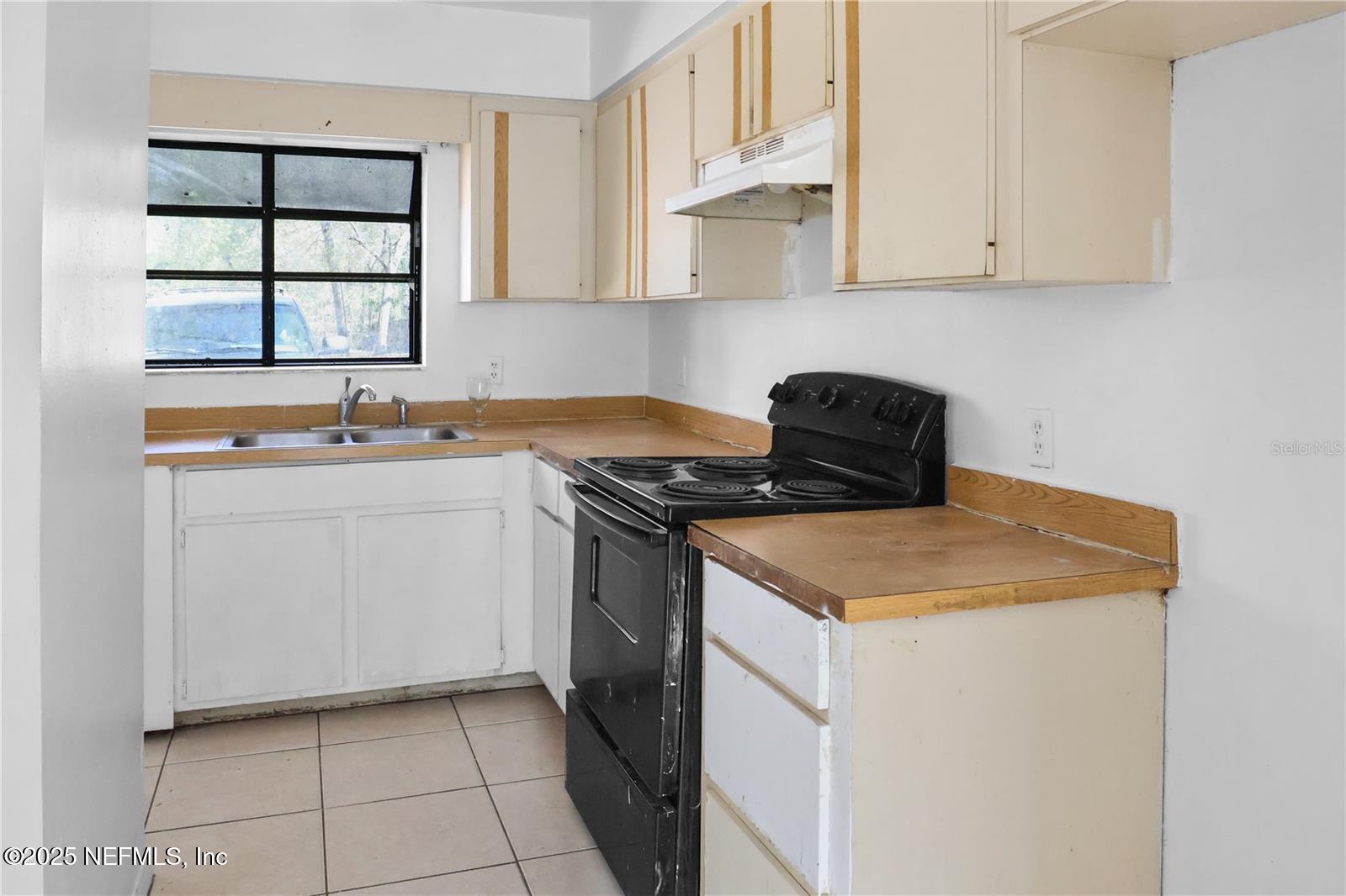 1110 Southwest 62nd Terrace Gainesville, FL 32607 - Photo 14 of 24 a kitchen with a sink stove and cabinets