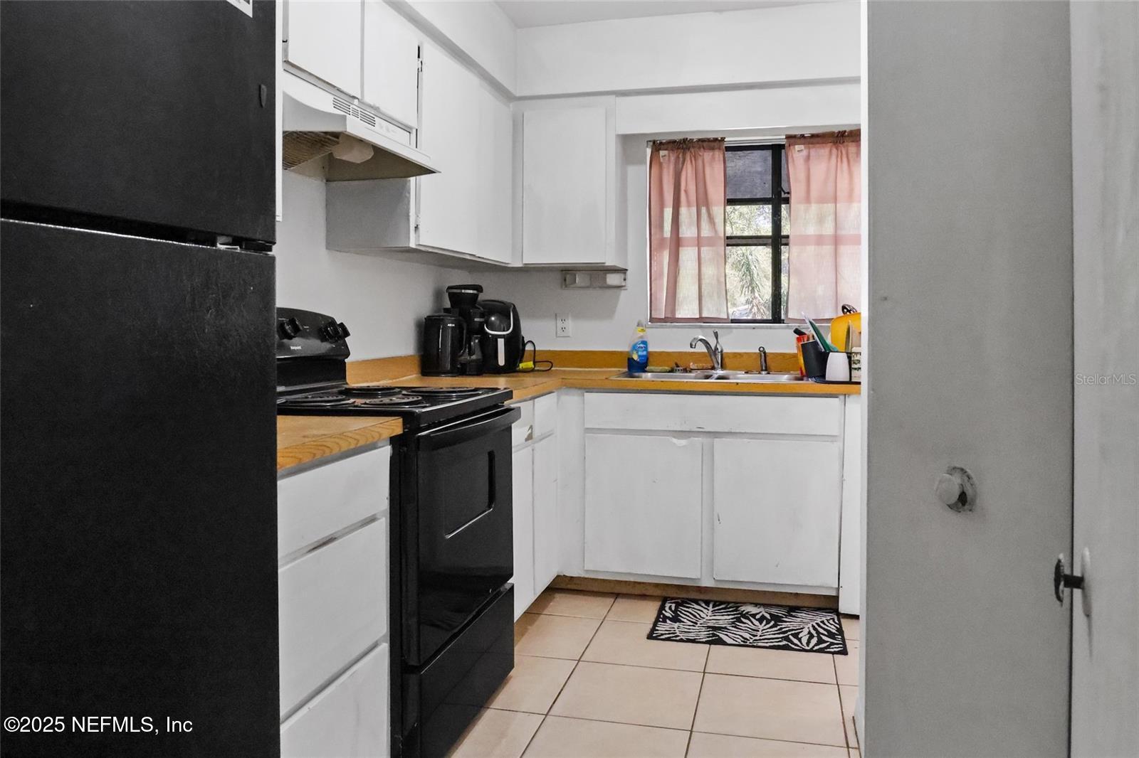 1110 Southwest 62nd Terrace Gainesville, FL 32607 - Photo 22 of 24 a kitchen with a sink a stove and cabinets