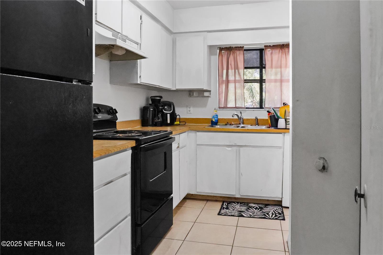 1110 Southwest 62nd Terrace Gainesville, FL 32607 - Photo 6 of 24 a kitchen with a sink a stove and cabinets