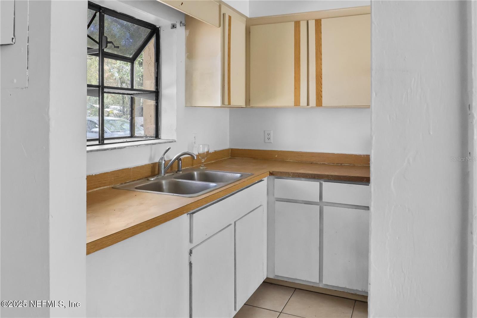 1110 Southwest 62nd Terrace Gainesville, FL 32607 - Photo 7 of 24 a kitchen with white cabinets and a sink