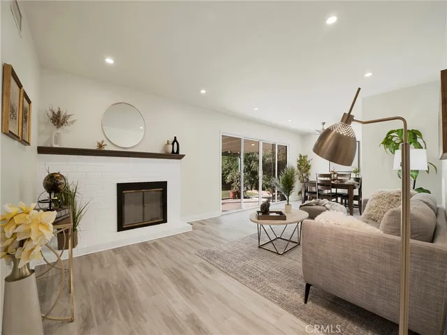 a living room with furniture a fireplace and a floor to ceiling window