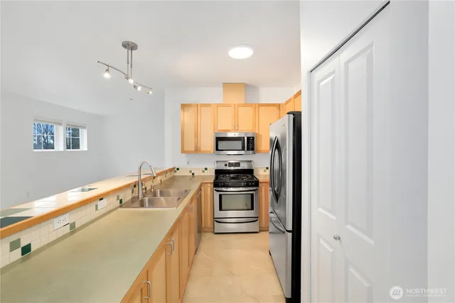 a kitchen with granite countertop a refrigerator stove and sink