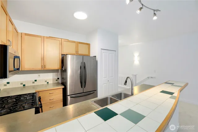 a kitchen with a sink a refrigerator and cabinets