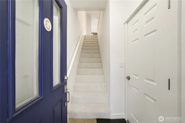 a view of a hallway with wooden floor and entryway