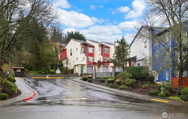 a view of a white house next to a road and yard