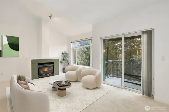 a living room with furniture a fireplace and a floor to ceiling window