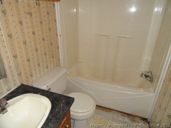 240 Youngs Road Vass, NC 28394 - Photo 7 of 8 a bathroom with a granite countertop toilet a sink and bathtub