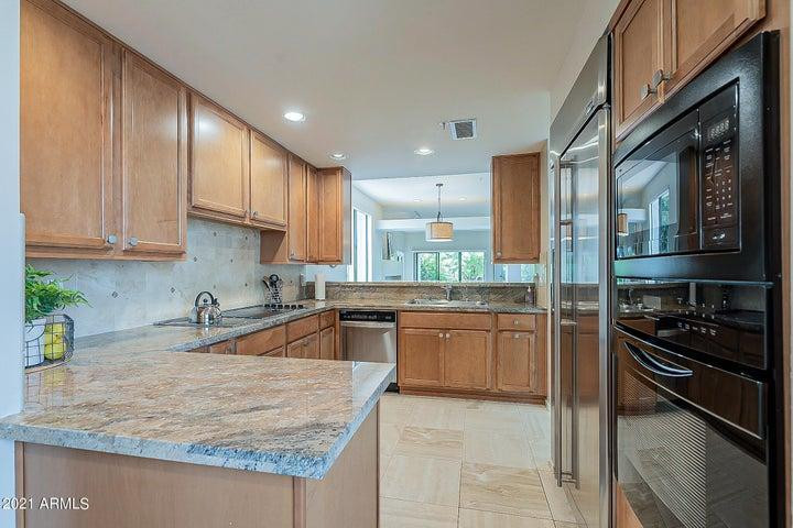 7700 East Gainey Ranch Road, Unit 153 Scottsdale, AZ 85258 - Photo 4 of 24 a kitchen with stainless steel appliances granite countertop a sink stove and refrigerator