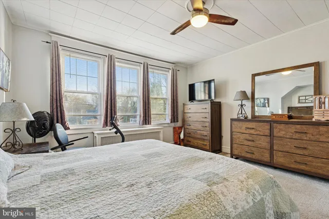 a bedroom with a bed a large window and flat screen tv