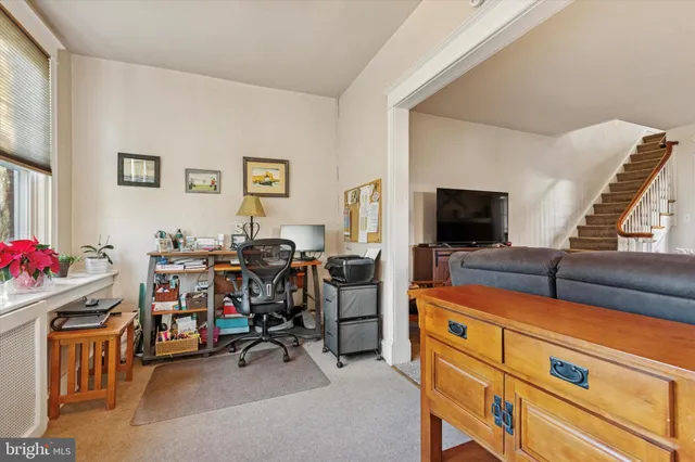 a view of a livingroom with workspace and a flat screen tv