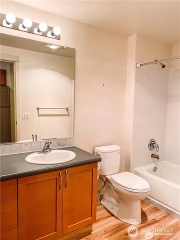a bathroom with a granite countertop sink mirror vanity and toilet