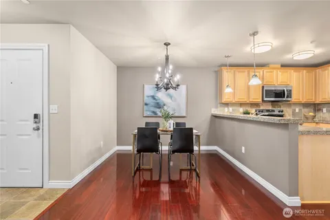 a dining room with furniture a chandelier and wooden floor