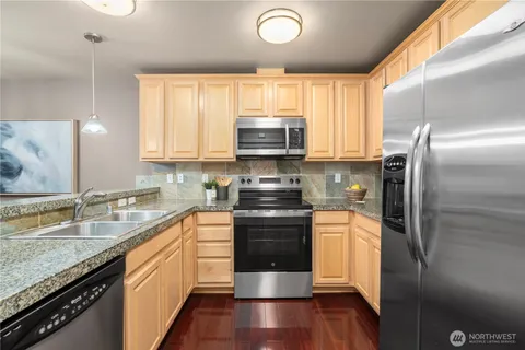 a kitchen with stainless steel appliances granite countertop a stove a refrigerator and a sink