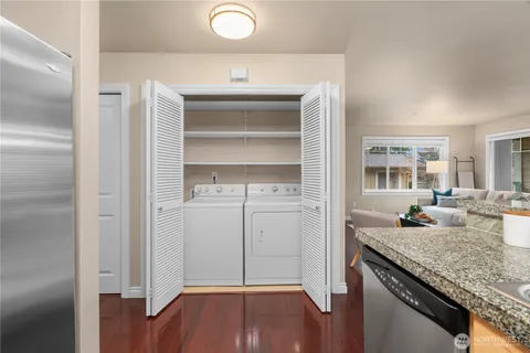 a kitchen with granite countertop a sink cabinets and wooden floor