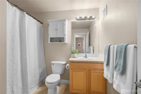a bathroom with a granite countertop sink toilet and mirror