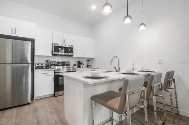 a kitchen with stainless steel appliances a sink a stove a refrigerator and cabinets