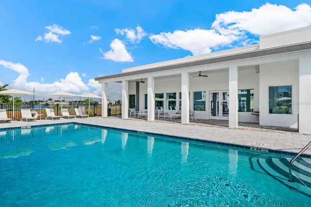 a view of a house with swimming pool and sitting area
