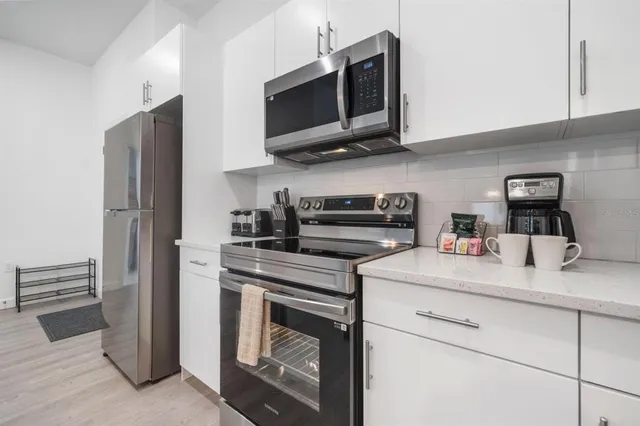 a kitchen with stainless steel appliances granite countertop a stove microwave and refrigerator