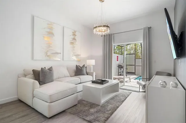 a living room with furniture a large window and a flat screen tv