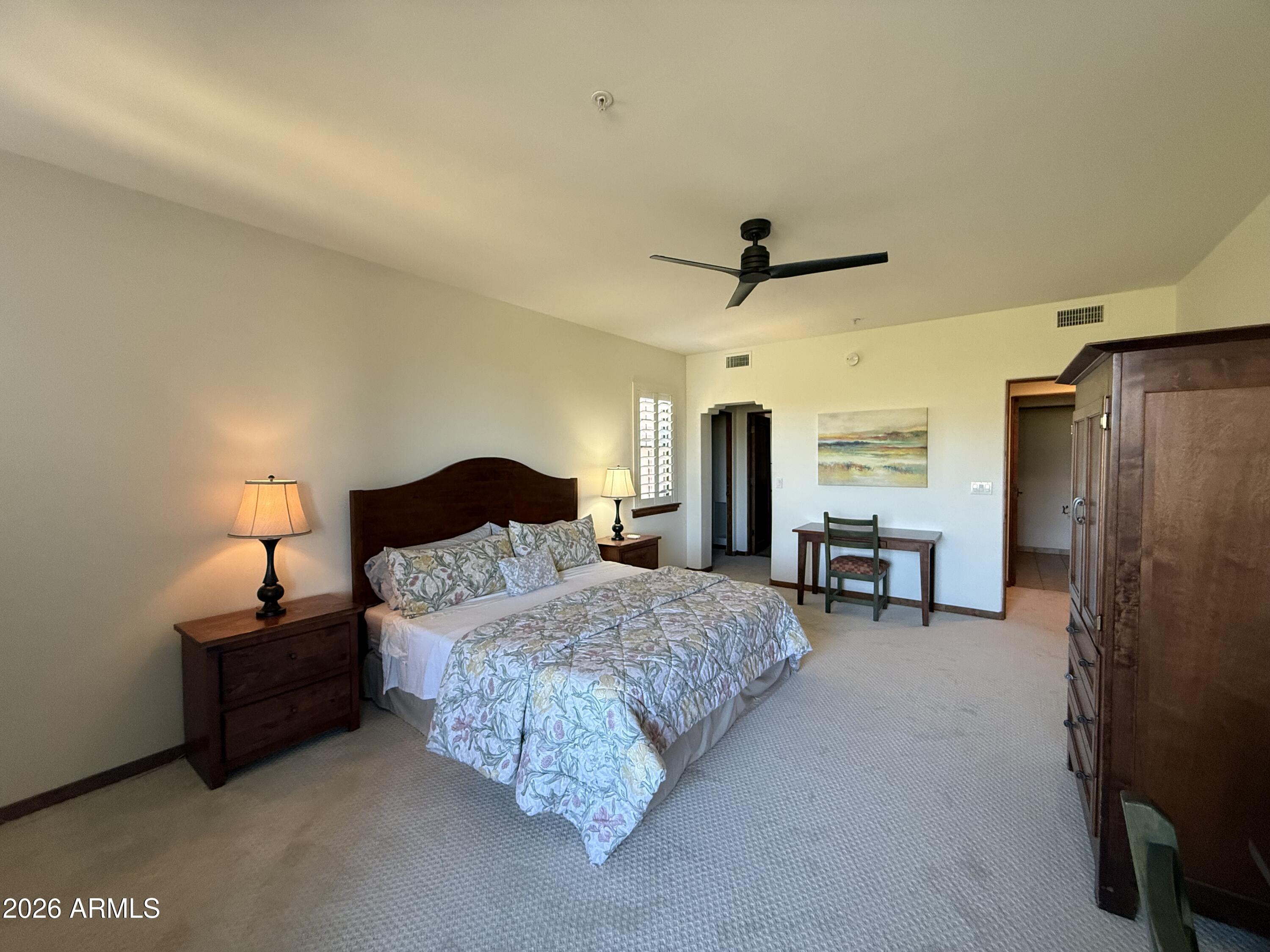 36601 North Mule Train Road, Unit D18 Carefree, AZ 85377 - Photo 21 of 57 a spacious bedroom with a bed and a ceiling fan