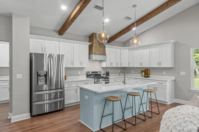 a kitchen with kitchen island a sink stove and refrigerator