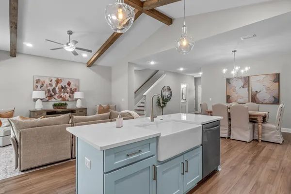 a view of kitchen island a sink and a chandelier