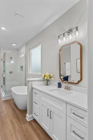 a bathroom with a double vanity sink mirror and bathtub