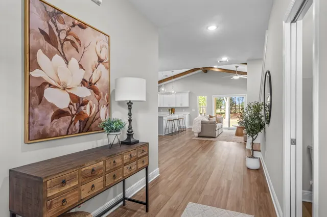 a view of a hallway with wooden floor and a furniture