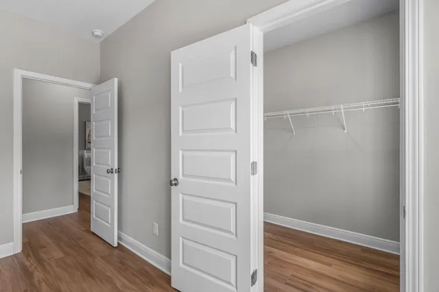 a view of walk in closet with wooden floor