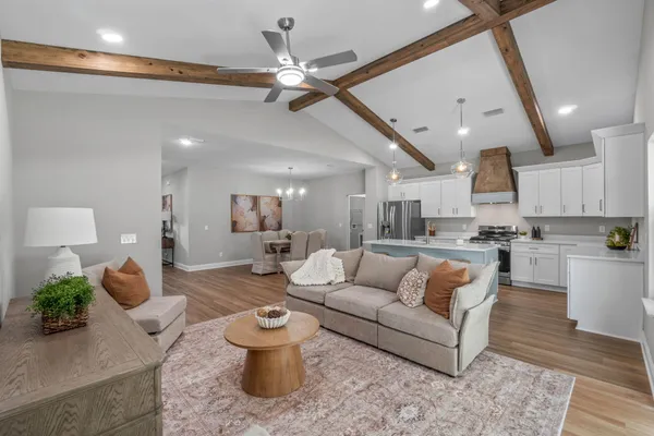 a living room with furniture and a view of kitchen