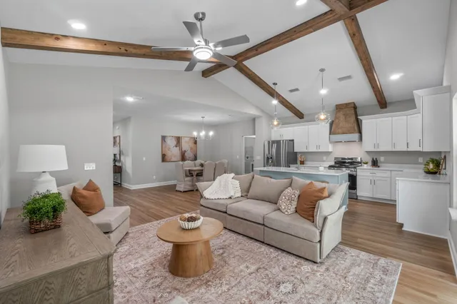 a living room with furniture and a view of kitchen