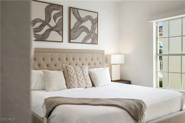 a bedroom with a bed and painting on the wall