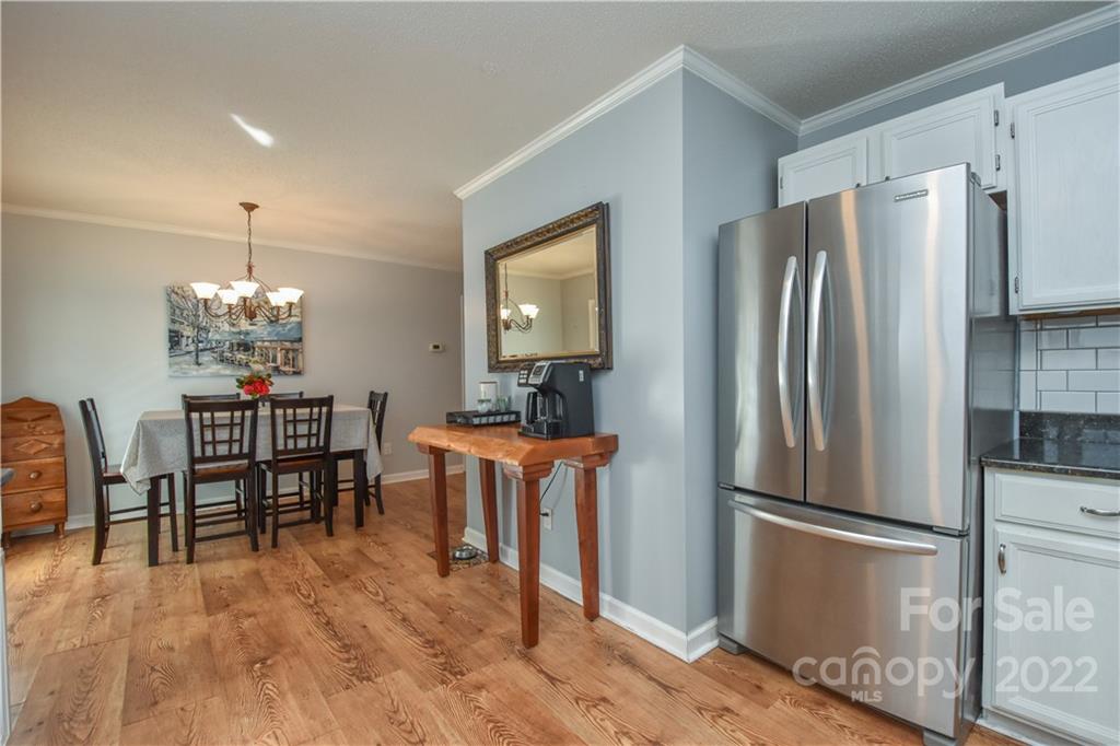 3403 Lake Shore Road South Denver, NC 28037 - Photo 10 of 37 a kitchen with stainless steel appliances a refrigerator a stove a dining table and chairs with wooden floor