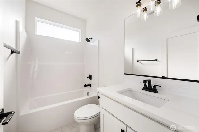 a bathroom with a sink a toilet a mirror and shower