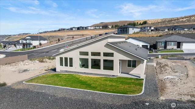 a view of a big house with a big yard and large tree