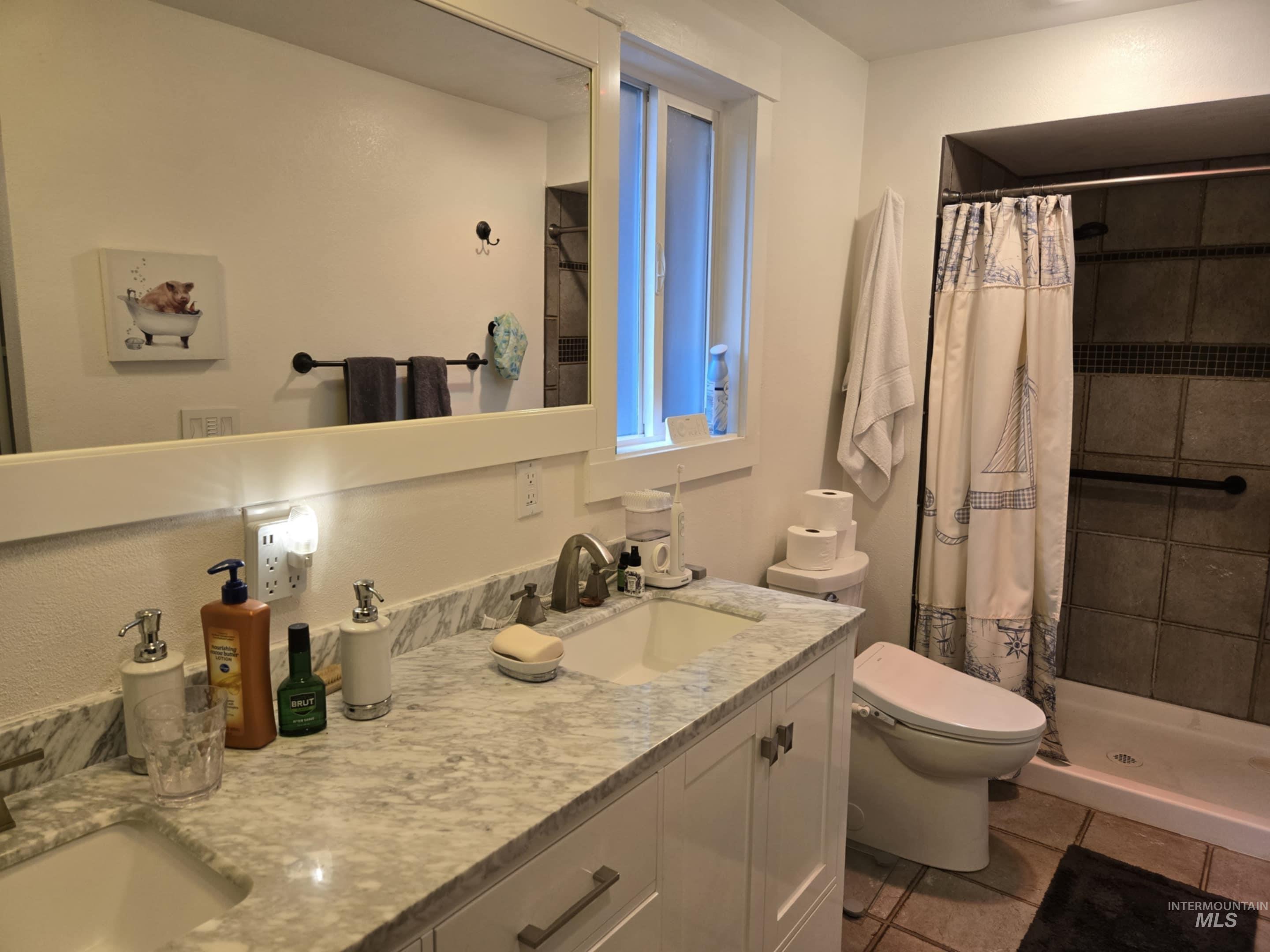 2141 Jackson Creek Road Council, ID 83612 - Photo 23 of 45 A stone countertop and dual vanity set the tone, while a tiled walk-in shower and window make the bathroom both stylish and bright
