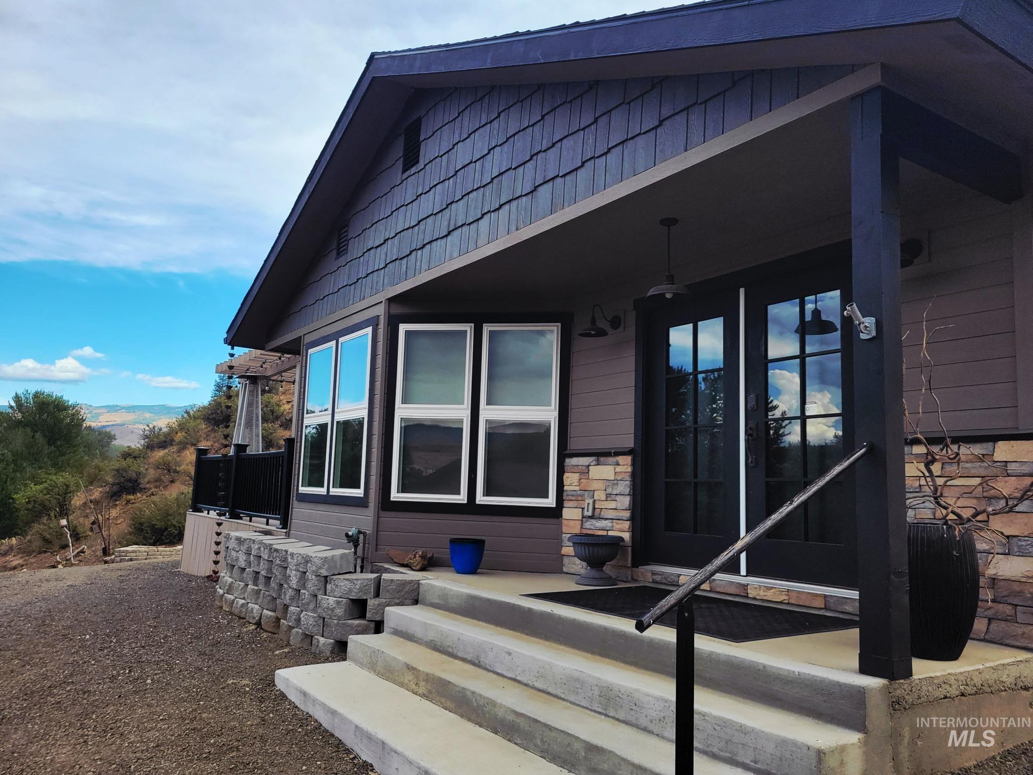 2141 Jackson Creek Road Council, ID 83612 - Photo 3 of 45 Beautiful barn doors slide inside to cover the French doors, offering both style and privacy. Covered deck looks out over the river, creating a space as functional as it is scenic