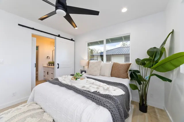 a bedroom with a bed and a potted plant