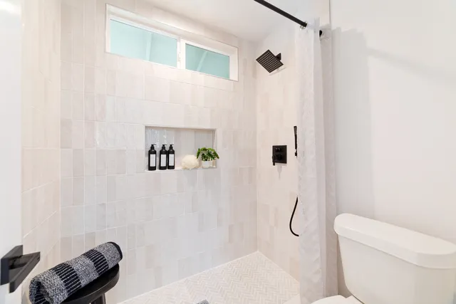 a bathroom with a toilet and a shower